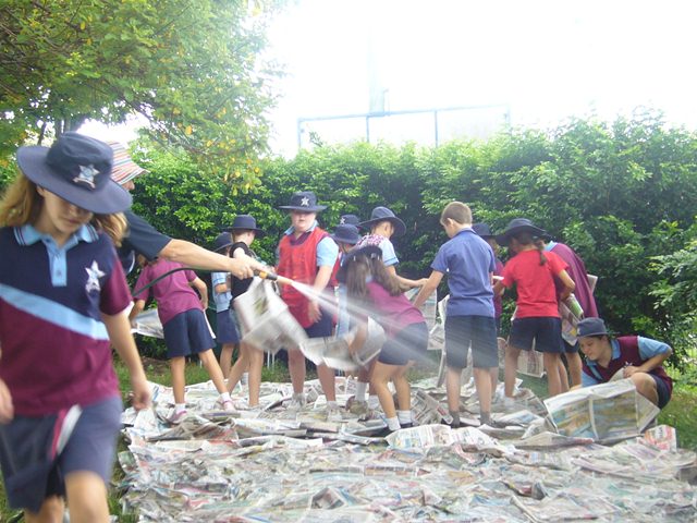 Students taking part in an outdoor hands‑on activity on school grounds.