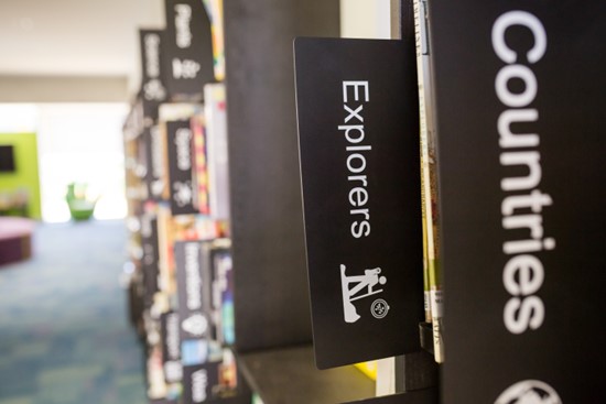 Book category labels on school library shelves.