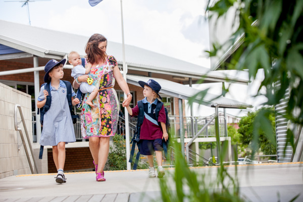 Adult and students walking together on school grounds.