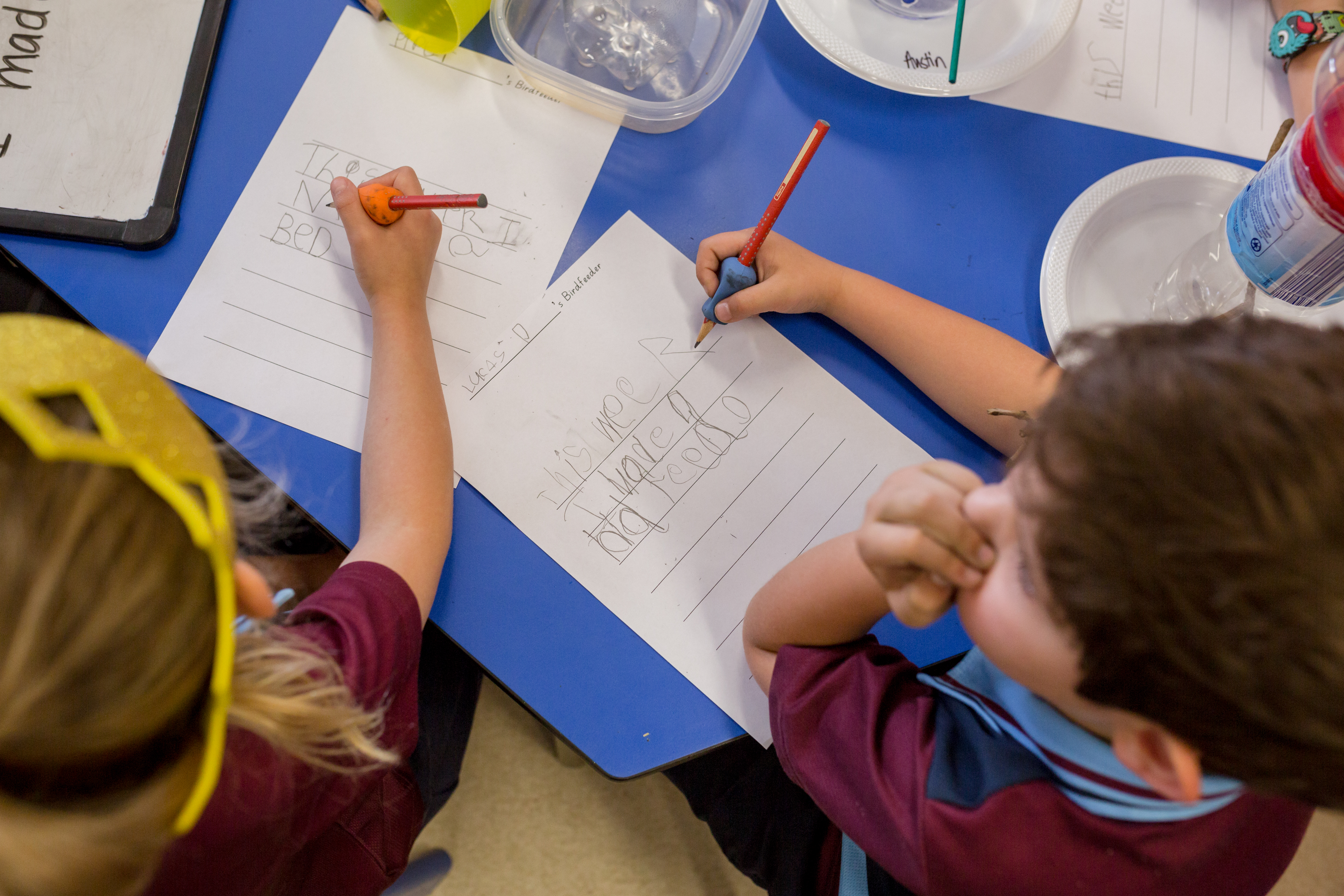 Students practising writing during a classroom activity.