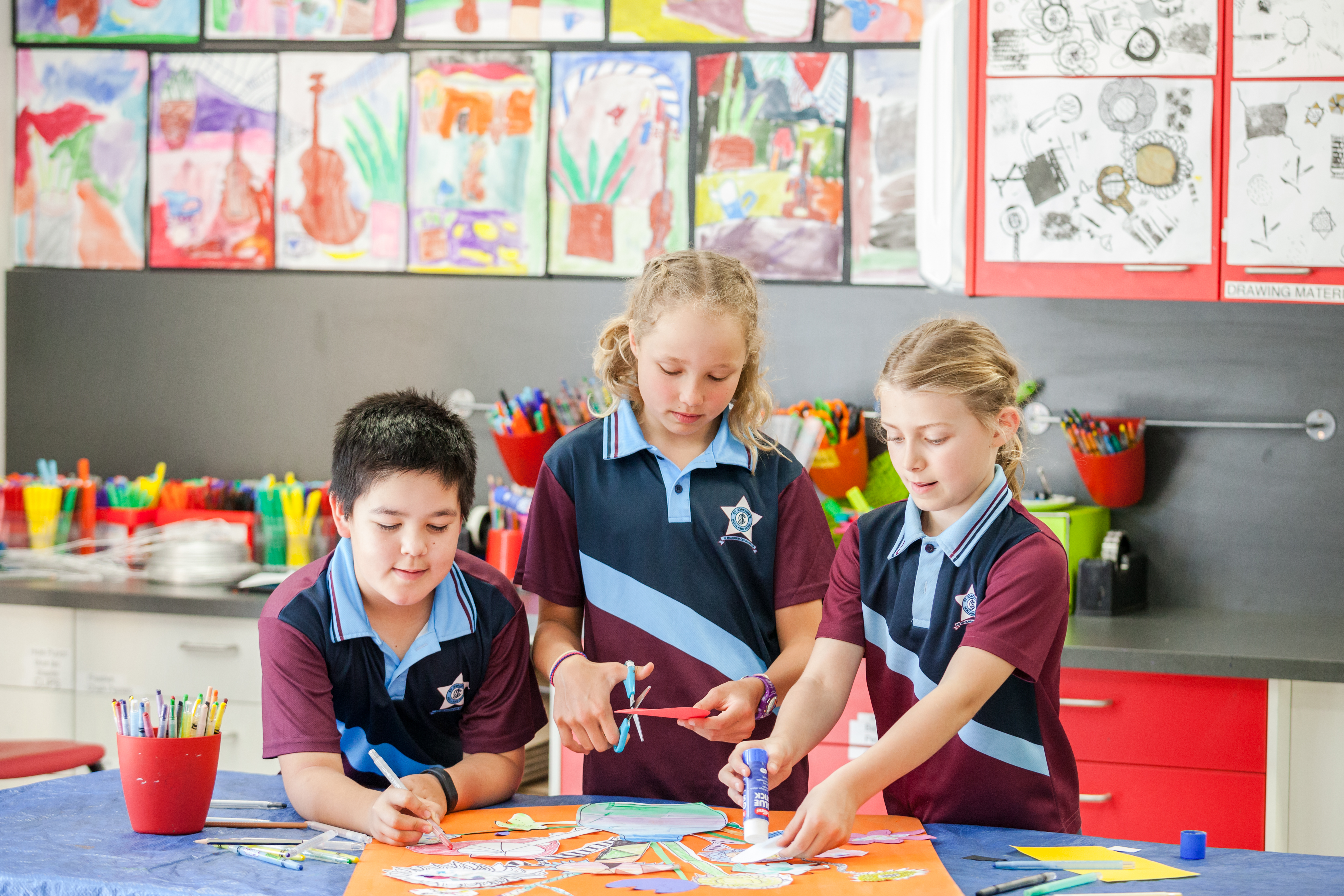 Students collaborating on an art activity in a classroom.